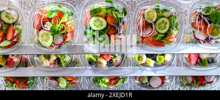 Plastikboxen mit vorverpackten Obst- und Gemüsesalaten Stockfoto