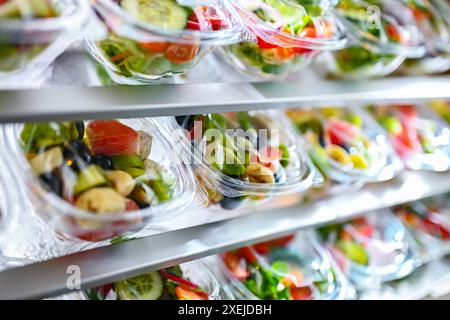 Plastikboxen mit vorverpackten Obst- und Gemüsesalaten Stockfoto