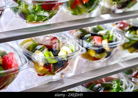 Plastikboxen mit vorverpackten Obst- und Gemüsesalaten Stockfoto