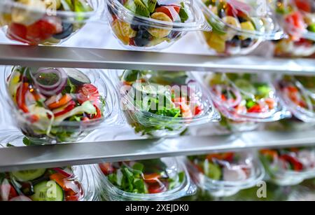 Plastikboxen mit vorverpackten Obst- und Gemüsesalaten Stockfoto