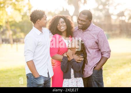 Familie hält sich gegenseitig lachend und lächelnd Stockfoto
