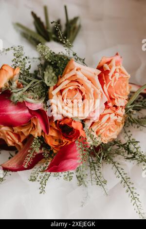 Brautstrauß mit Pfirsichrosen und magentafarbenen Calla-Lilien Stockfoto