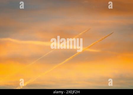 Jet-Flugzeuge mit Kondensstreifen am dramatischen Morgenhimmel Stockfoto