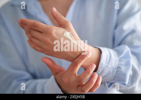Hands in a blue shirt smear cream. Stockfoto