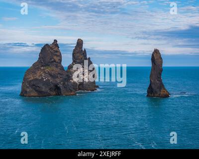 Majestätische Black Rock Formationen, die aus dem Wasser des Blauen Ozeans in Island aufsteigen Stockfoto