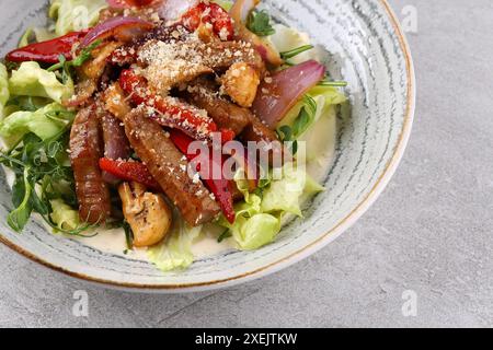 Rindersteak-Salat mit Kirschtomaten, Gurken, roten Zwiebeln, Romaine-Salat und Limettensenf-Olivenöl-Salatdressing Stockfoto