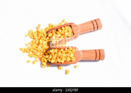 Toor dal oder gespaltene gelbe Linsen in einem Holzlöffel isoliert. Geteilte Kichererbsen in einem Beutel, auch bekannt als Chana Dal, gelbe Chana geteilte Erbsen, getrocknete Kichererbsen Stockfoto