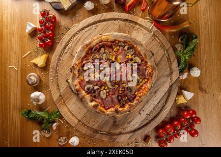 Blick von oben auf Pizza Capricciosa mit Pilzen, Schinken, Oliven auf Holzbrett Stockfoto