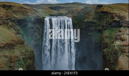 Aus der Vogelperspektive des majestätischen Wasserfalls, der die steilen Klippen in Island hinunterstürzt Stockfoto