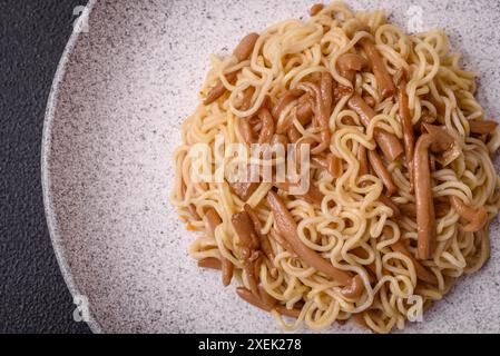 Köstliches asiatisches Gericht mit Reisnudeln, Paprika, Pilzen und Gewürzen Stockfoto