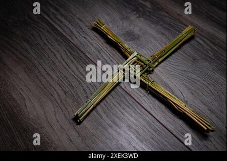 Religion. Kreuz von Saint Brigid, Schutzpatron von Irland. Imbolc 1. Und 3. Februar 2025 auf Holztisch. Stockfoto