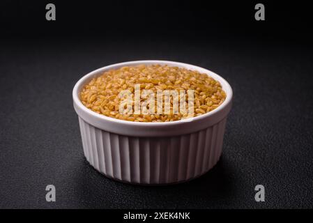 Bulgur-Weizenkörner sind im rohen Zustand gelb gefärbt Stockfoto