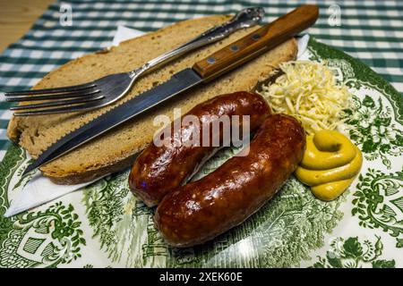 Käsewürste mit Senf, Meerrettich und Bauernbrot. Die Würstchen werden aus Rind- und Schweinefleisch hergestellt und enthalten auch Käsestücke. Typisches Gericht auf einem Bergbauernhof im Großarltal. Alle Hauptzutaten der angebotenen Gerichte müssen aus eigener Produktion stammen. Hausgemachte Würstchen mit Senf, Brot und Meerrettich. Filzmoosalm, Großarl, Salzburg, Österreich Stockfoto