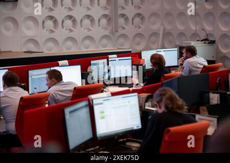 Neuss, Deutschland. Juni 2024. Polizisten sitzen im IPCC. Bundeskanzler Scholz (SPD) und NRW-Innenminister Reul (CDU) besuchen das Zentrum für internationale polizeiliche Zusammenarbeit. Das International Police Cooperation Center bringt 300 Polizeibeamte aus der Bundesregierung, den bundesländern und den 24 teilnehmenden Ländern zusammen, um sich über die Europameisterspiele zu informieren. Quelle: Fabian Strauch/dpa/Alamy Live News Stockfoto