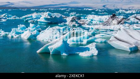 Luftaufnahme der Eisberge, die im tiefblauen Wasser unter dem klaren blauen Himmel schwimmen Stockfoto