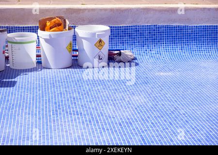 Bei Reparatur- und Dichtungsarbeiten standen Abfallbehälter neben einem leeren Pool. Stockfoto