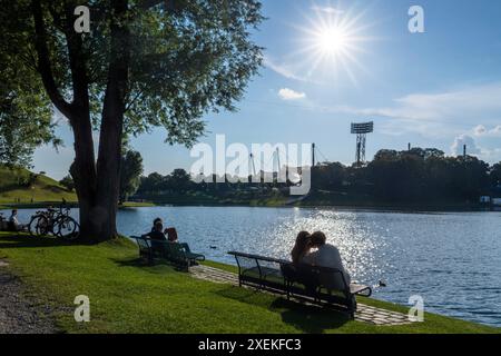 Sommer im Olympiapark, München, Juni 2024 Deutschland, München, Juni 2024, Sommer im Olympiapark, Münchner und Münchnerinnen entspannen am Olympiasee, Sonnenschein pur, Park, *** Sommer im Olympiapark, München, Juni 2024 Deutschland, München, Juni 2024, Sommer im Olympiapark, Münchner entspannen am Olympischen See, Sonnenschein pur, Park, Stockfoto