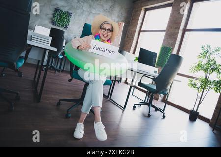 Foto von glücklicher charmanter Senior Dame Sekretärin tragen formelles Hemd peparing Sommerurlaub Indoor Werkstatt Arbeitsplatz Loft Stockfoto