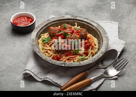 Spaghetti, serviert mit Fleischbällchen und Tomatensauce in rustikaler Schüssel, italienische Küche Stockfoto