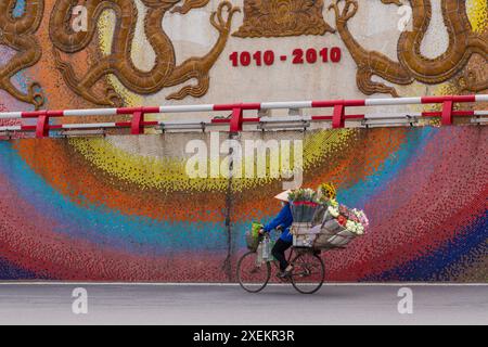 Blumenhändler Blumenhändler auf Fahrrad an Mosaikwand in Hanoi, Ha Noi, Nordvietnam, Asien im Juni Stockfoto