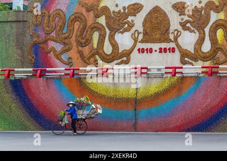 Blumenhändler Blumenhändler auf Fahrrad an Mosaikwand in Hanoi, Ha Noi, Nordvietnam, Asien im Juni Stockfoto