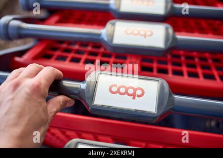 Nago Torbole, Gardasee, Italien - 27. Juni 2024: Ein Kunde greift nach einem Einkaufswagen im italienischen Supermarkt Coop *** ein Kunde greift nach einem Einkaufswagen im italienischen Supermarkt Coop Stockfoto