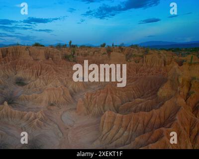 Aus der Vogelperspektive auf die Tatacoa-Wüste in Kolumbien mit ihren markanten roten Felsformationen und einzigartigen erodierten Landschaften, die im Sonnenlicht getaucht sind. Stockfoto