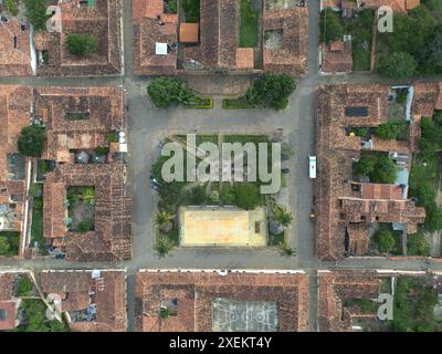 Ein Bild über dem Kopf zeigt den Platz von Guane, Santander, mit seinem symmetrischen Layout von Gärten und historischen Gebäuden mit charakteristischen roten Dächern. Stockfoto