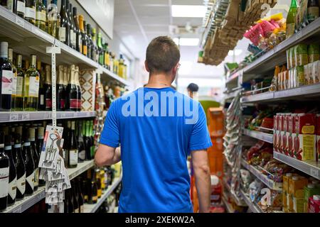 Nago Torbole, Gardasee, Italien - 27. Juni 2024: Ein Urlauber kauft im Coop Supermarkt in Torbole, Italien, und genießt die breite Auswahl an regionalen Lebensmitteln und Getränken *** ein Urlauber kauft im Coop Supermarkt in Torbole, Italien, ein und genießt die breite Auswahl an regionalen Lebensmitteln und Getränken Stockfoto