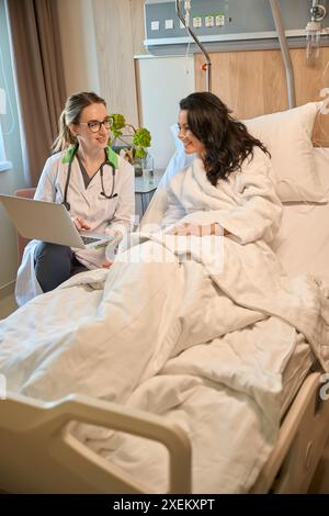 Zwei Frauen kommunizieren in einem Krankenhauszimmer Stockfoto