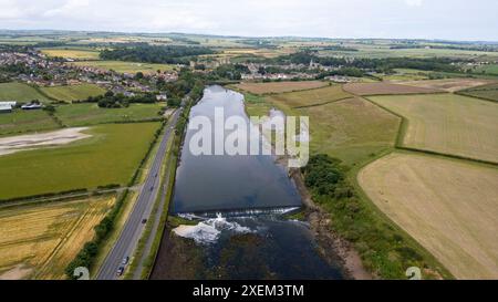 Aus der Vogelperspektive auf den Fluss Coquet in Amble und Warkworth Castle in der Ferne, Northumberland, England. Stockfoto