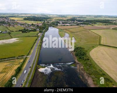 Aus der Vogelperspektive auf den Fluss Coquet in Amble und Warkworth Castle in der Ferne, Northumberland, England. Stockfoto