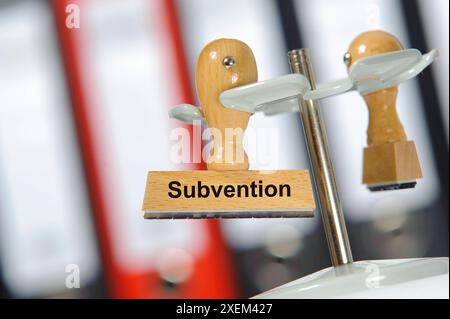 Subvention in einem Büro mit Aktenordner hängt ein Holzstempel mit dem Aufdruck: Subvention *** Subvention Ein Holzstempel mit dem Aufdruck Subvention hängt in Stockfoto