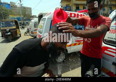 Freiwillige der Edhi Foundation bewässern Pendler, um die Hitze der sengenden Sonne an heißen Tagen der Sommersaison zu überwinden, da der Metropolitan am Freitag, den 28. Juni 2024, in der Tower Area in Karachi extrem von Hitzewellen erfasst wird. Das pakistanische Meteorologische Department (PMD) hat angekündigt, dass Karachi heute Abend gemäßigte bis leichte Schauer erleben wird, nachdem gestern ein erheblicher Regenschauer in der Stadt aufgetreten ist. Stockfoto