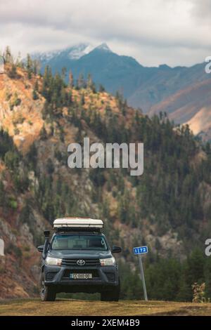 Sportfahrzeug parkt an einer Kilometermarkierung in Omalo im Tusheti-Nationalpark, Georgia; Omalo, Kakheti, Georgia Stockfoto