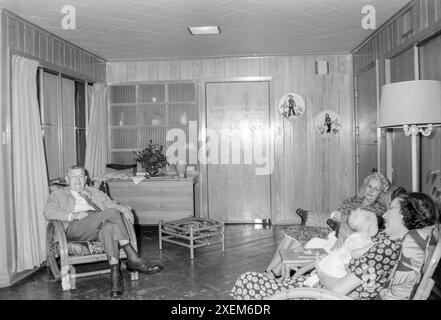 Magnolia, Arkansas, USA – 22. Juni 2024: Horizontale Aufnahme einer Mutter aus den frühen 1950er Jahren, die ihren neuen Jungen hält, während ihre Eltern zuschauen. Stockfoto