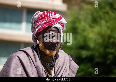 Ein somalischer Ältester, der in Äthiopiens Afar-Region lebt, in traditioneller Kleidung mit einem roten Schal um den Kopf und einem orangefarbenen Henna-gefärbten Bart gekleidet ist Stockfoto