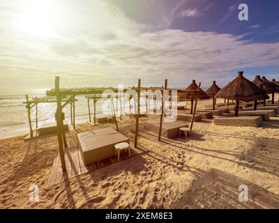 Balinesische Betten an einem Strand mit feinem goldenem Sand unter der glitzernden karibischen Sonne und dem Meer im Hintergrund, eine ideale Umgebung für einen Sommerurlaub Stockfoto