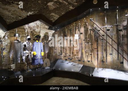 Die Waffenkammer mit verschiedenen Waffen und Kleidungsstücken und Rüstungen im Estnischen Geschichtsmuseum — große Gildenhalle in Tallinn, Estland. Stockfoto