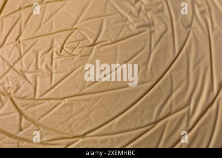 Das Bild ist eine raue Textur eines braunen Stücks Papier oder Plastik. Das Papier scheint gerissen zu sein und hat eine raue Textur. Das Papier hat die Form eines ci Stockfoto