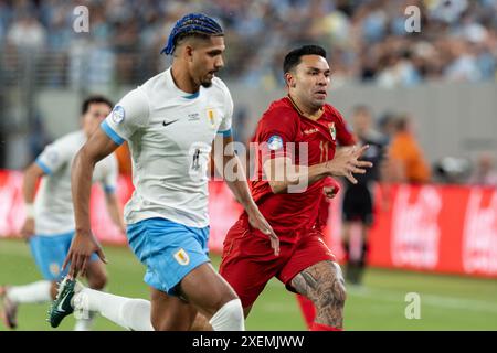 Ronald Araujo aus Uruguay (4) und Carmelo Algaranaz (11) aus Bolivien verfolgen den Ball während des Gruppenspiels während des Copa America Turniers im MetLife Stadium in East Rutherford, New Jersey am 27. Juni 2024. Uruguay gewann mit 5:0 Stockfoto