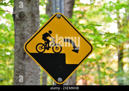 Mountainbike-Trail, Warnschild für plötzlichen Sturz, schwarzes und gelbes Warnschild. Stockfoto