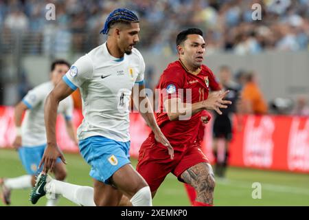 East Rotherford, USA. Juni 2024. Ronald Araujo aus Uruguay (4) und Carmelo Algaranaz (11) aus Bolivien verfolgen den Ball während des Gruppenspiels während des Copa America Turniers im MetLife Stadium in East Rutherford, New Jersey am 27. Juni 2024. Uruguay gewann mit 5:0. (Foto: Lev Radin/SIPA USA) Credit: SIPA USA/Alamy Live News Stockfoto