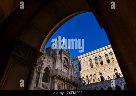 Gerahmter Blick auf ein Detail der venezianischen gotischen Architektur des Dogenpalastes (Palazzo Ducale) vor einem blauen Himmel; Venedig, Venetien, Italien Stockfoto