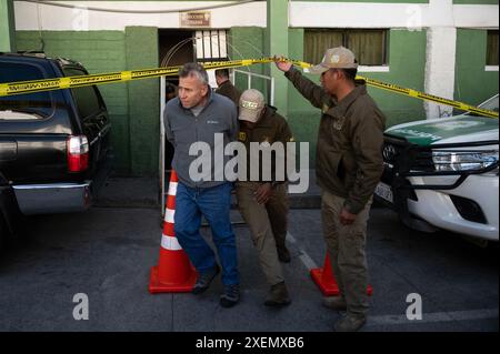 La Paz, Bolivien. Juni 2024. Juan Mario Paulsen (l), der nach dem gescheiterten Putschversuch verhaftet wurde, wird von Sicherheitskräften aus dem Hauptquartier der Sondereinheit FELCC geführt. Quelle: Radoslaw Czajkowski/dpa/Alamy Live News Stockfoto