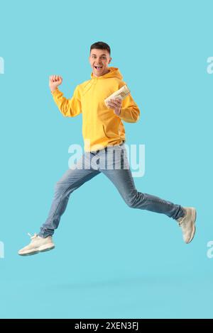 Springender junger Mann mit leckerem Döner-Kebab auf blauem Hintergrund Stockfoto