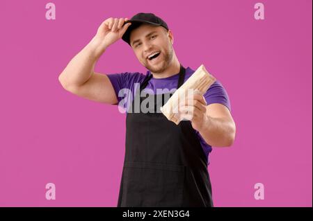 Koch mit leckerem Döner-Kebab auf violettem Hintergrund Stockfoto