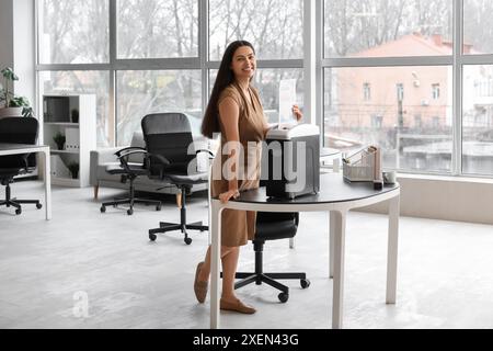 Junge Sekretärin, die Dokumente mit Schredder im Büro vernichtet Stockfoto