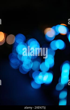 Verschwommene, blaue und goldene Lichter einer Kunstinstallation vor einem Nachthimmel; Bangkok, Thailand Stockfoto
