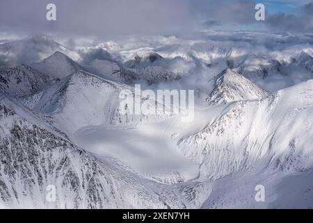 Aus der Vogelperspektive auf die schneebedeckten Berggipfel und Gletscher des Kluane-Nationalparks, aufgenommen während des Übergangs zwischen Herbst und Winter Stockfoto